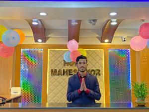 a man standing in front of a wall with balloons at Hotel Maheshwor in Pashupatināth