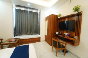 a bedroom with a bed and a tv and a window at MK House in Greater Noida +19 photos