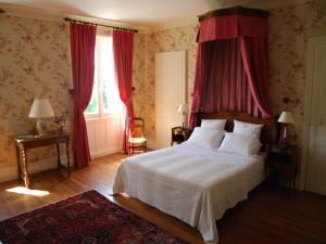 Schlafzimmer mit einem großen Bett und roten Vorhängen in der Unterkunft Chambres d'Hôtes Le Château de la Plante in Thuré