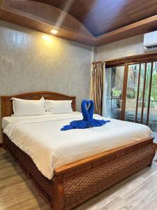 ein Bett mit einem blauen Band darauf in der Unterkunft Anda Resort in Ko Lipe