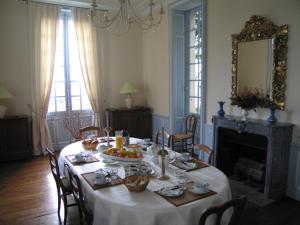 un comedor con una mesa con un bol de fruta. en Chambres d'Hôtes Le Château de la Plante en Thuré