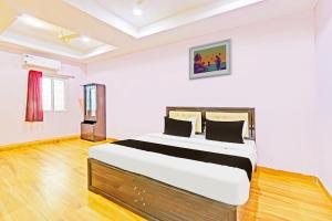a bedroom with a large bed in a room at Hotel O Nandhi Inn in Vemalwāda