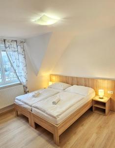 a bedroom with a large bed and a window at MOTOREST-PENSION U HRACHŮ,s.r.o. in Klatovy