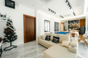 a living room with a christmas tree and a couch at PHUM Villa Songkhla in Ban Saphan Yao