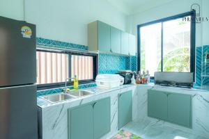 a kitchen with a sink and a refrigerator at PHUM Villa Songkhla in Ban Saphan Yao