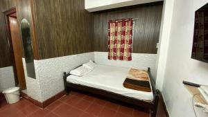 a small room with a small bed with a window at Hotel Raj Palace in Jāmb