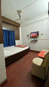 a bedroom with a bed and a tv on a wall at Hotel Raj Palace in Jāmb