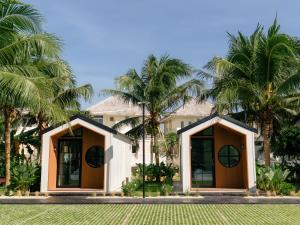 a house with palm trees in front of it at PHUM Villa Songkhla in Ban Saphan Yao