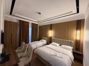 a hotel room with two beds and two chairs at Alatau hotel in Shymkent +18 photos