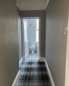 a hallway with a bathroom with a toilet and a sink at Arundel House in Whitby +51 photos