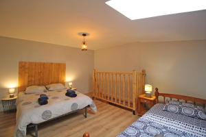 a bedroom with two beds and a crib at Familial 'le chiron' in Thiat