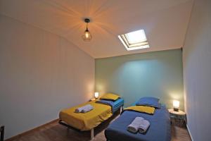 two twin beds in a room with a window at Familial 'le chiron' in Thiat