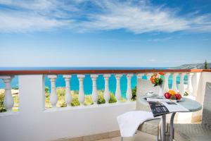 un tavolo e sedie su un balcone con vista di Hotel Santa Lucia a Parghelia