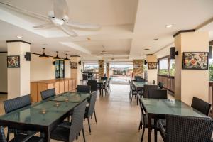 a dining room with tables and chairs at Ratana Hotel Chalong in Rawai Beach