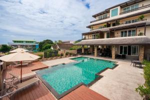 an image of a swimming pool in front of a building at Ratana Hotel Chalong in Rawai Beach +25 photos