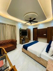 a bedroom with a bed with a ceiling fan and a couch at MK House in Greater Noida