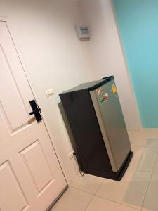 a small refrigerator in a room next to a door at อุดมสุข BTS udomsuk in Bangna