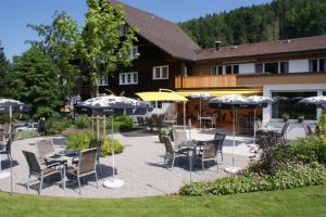 eine Terrasse mit Tischen, Stühlen und Sonnenschirmen in der Unterkunft Landgasthof Sternen in Bühler