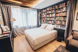 a bedroom with a bed and bookshelves at La suite heart of le Marais - quartier des enfants rouges in Paris
