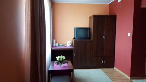 a room with a tv and a cabinet and a table at Dom Gościnny Korab in Kołobrzeg
