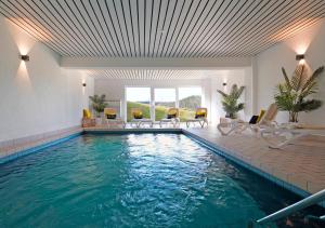 a swimming pool with chairs and a swimming pool at Hotel ThälerHäusle mit Schwimmbad in Furtwangen