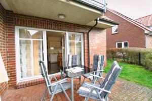 a patio with a table and chairs on a patio at Störtebeker in Norddeich