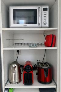 a microwave oven sitting on top of a shelf at Studio Rive Royale in Viroflay