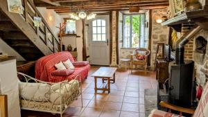 a living room with a red couch and a table at La ferme des souvenirs in Vaulry