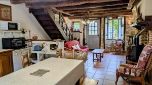 a kitchen and living room with a table and chairs at La ferme des souvenirs in Vaulry