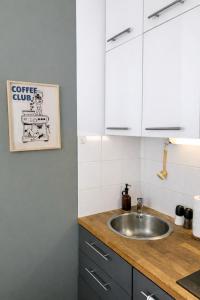 a kitchen with a sink and white cabinets at Studio Rive Royale in Viroflay