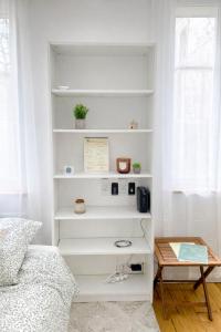 a room with white shelves and a bed and a table at Studio Rive Royale in Viroflay