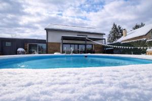 Ein mit Schnee bedeckter Swimmingpool vor einem Haus in der Unterkunft Shi-lu in Vurot