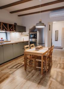 a kitchen with a wooden table and chairs at Relax Balaton Apartmanok in Balatonfüred