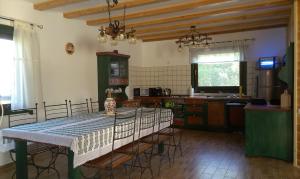 a kitchen with a table and chairs in a room at Csendes Bükk Kulcsosház in Izvoare