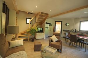 a living room with a spiral staircase and a living room at Trois ânes et un moulin in Bessines-sur-Gartempe