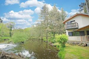a house with a river in front of it at Trois ânes et un moulin in Bessines-sur-Gartempe