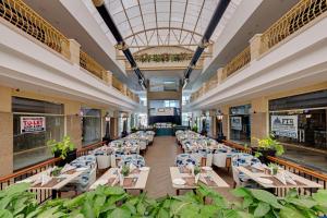 a restaurant with tables and chairs in a building at AR Suites Sohna Road in Gurgaon