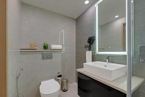a bathroom with a sink and a toilet at AR Suites Sohna Road in Gurgaon +20 photos