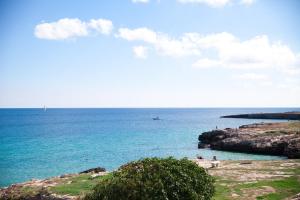 a group of people on the beach near the ocean at B&B Portorosso in Monopoli