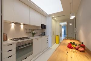 a kitchen with white cabinets and a wooden table at B&B Portorosso in Monopoli
