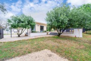 a house with two trees in front of it at Maison Jeannot - Climatisée avec piscine in Vers Pont du Gard