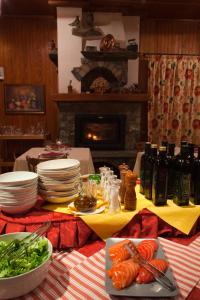 a table with plates of food and a fireplace at Hotel Le Campagnol in Champoluc