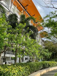 a building with trees and bushes in front of it at Beach condos at Pico de Loro Cove & possible Beach Club Access & Wi-Fi & Netflix, 42-50''TVs with Uratex beds & pillows, equipped kitchen, balcony, parking, guest registration fee is not included in Nasugbu