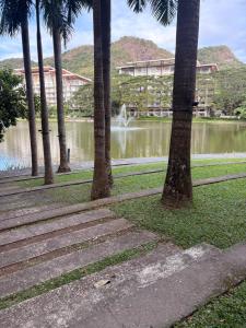 a park with palm trees and a pond with a fountain at Beach condos at Pico de Loro Cove & possible Beach Club Access & Wi-Fi & Netflix, 42-50''TVs with Uratex beds & pillows, equipped kitchen, balcony, parking, guest registration fee is not included in Nasugbu