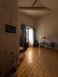 a living room with a wooden floor and a window at "White House Nakani" - Guesthouse near the centre in Mestia