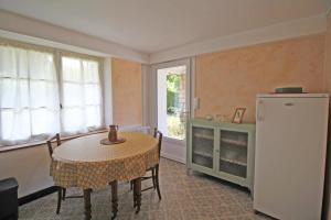 a dining room with a table and a refrigerator at - les vieux fourneaux - in Nantiat