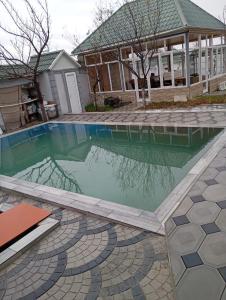 a swimming pool in front of a house at Moy Dom in İsmayıllı