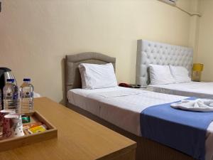 a hotel room with two beds and a table at Elflora Otel in Ceyhan +12 photos