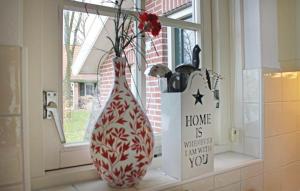 a red and white vase sitting on a window sill at Buitengoed het Lageveld 75 in Hoge-Hexel