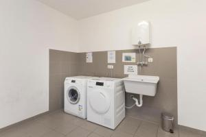 a bathroom with a washing machine and a sink at Alpinresort Kaprun 3 in Kaprun
